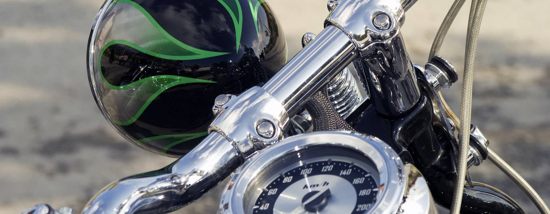 Close up picture of a motorcycle with a black helmet with green flames next to it | Picture used for Glasheen, Valles & Inderman Injury Lawyers | Hobbs Motorcycle Accident Attorney Page