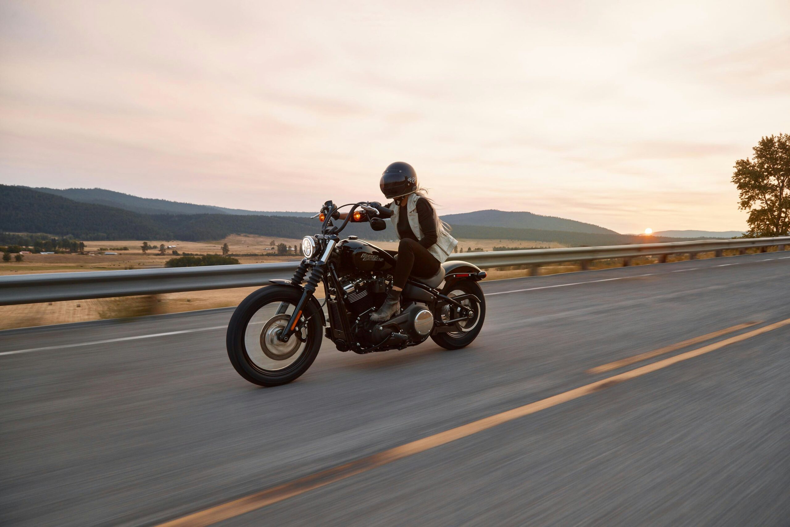 Picture showing a person riding a motorcycle, the landscape is blurred to show they are in motion; Depicting a situation that can lead to a motorcycle accident