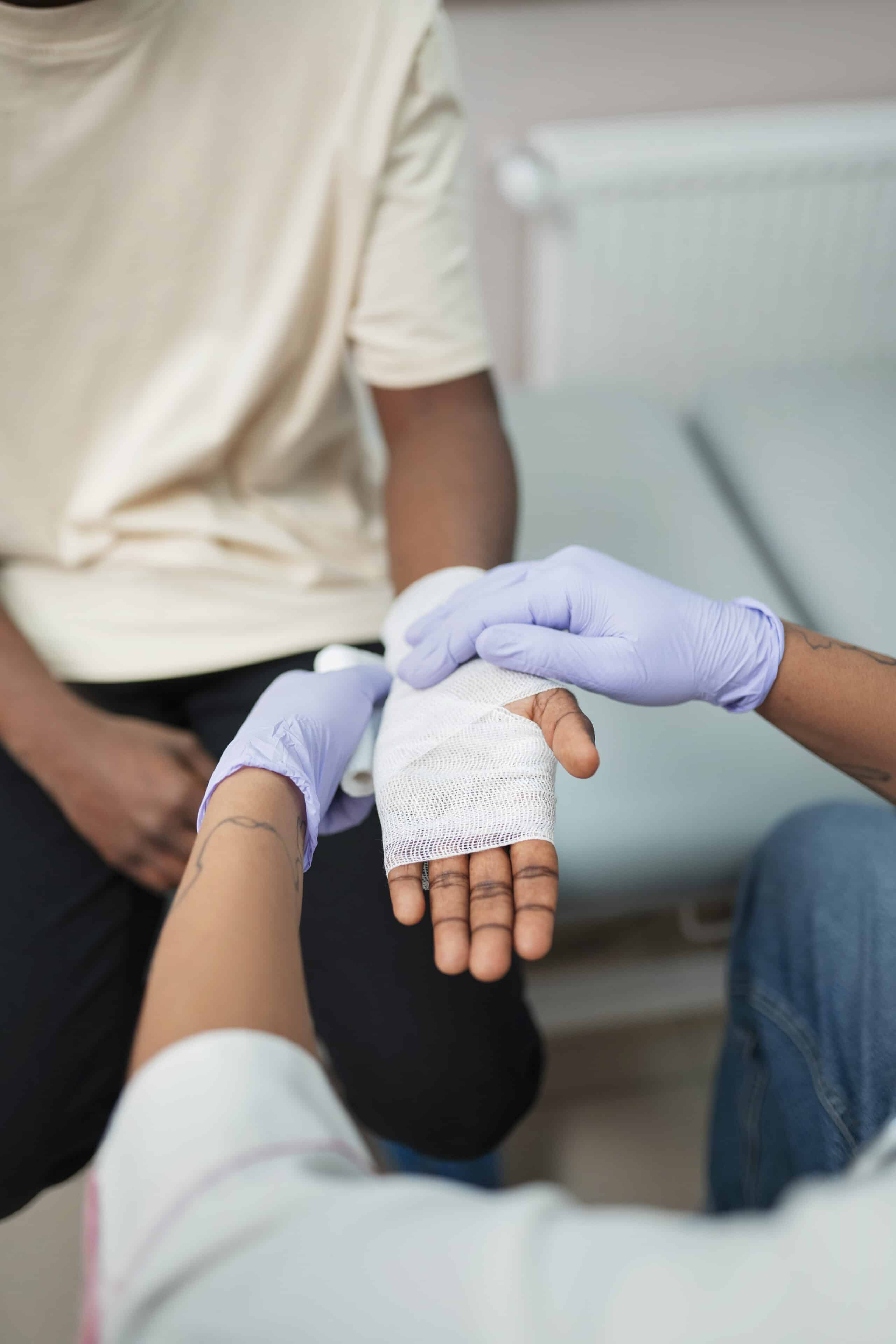 Picture showing a doctor wrapping a bandage on a patients hand, to show an example of treating a burn injury.